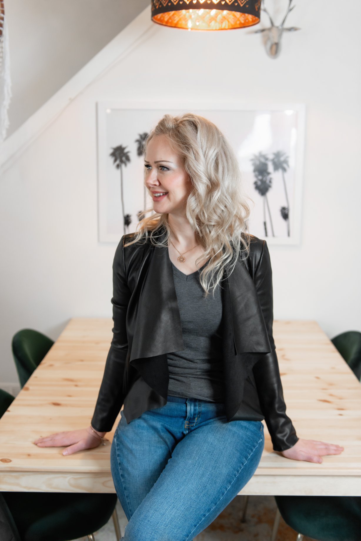 sarah sitting on top of a desk smiling at the camera